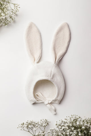 Organic Cotton Bunny Baby Bonnet in Milk/Oat on a White Backdrop with Gypsophilia