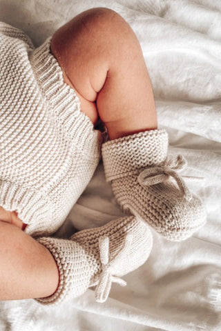 Baby feet wearing bloomers and booties